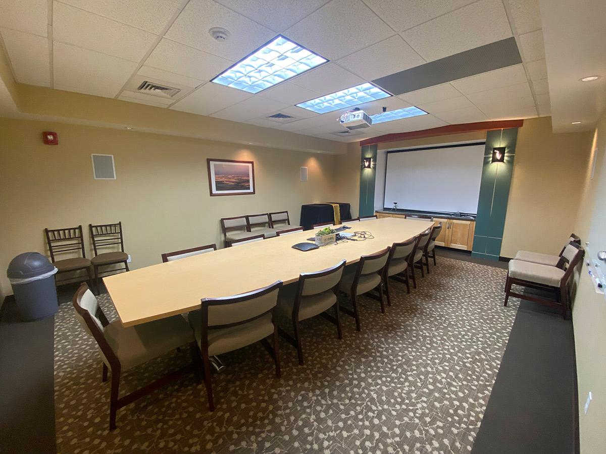 The whiteboard, conference room table and seats of the Morin Conference Room.